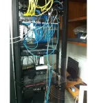 A computer server on the rack with a bunch of unorganized fibre cabling