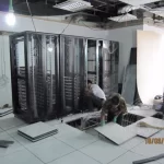 Two workers installing racks in a server room