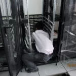 An IT technician is installing the vertical cable fibre and copper cabling in a server rack