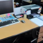 A desk with a computer and a printer