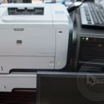 A keyboard on top of a CPU with a printer beside