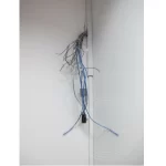 A bunch of wires protruding from the wall