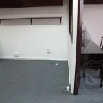 An empty office with a desk and chair on the side