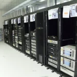 A room with several computer servers and housings arranged neatly in a server room